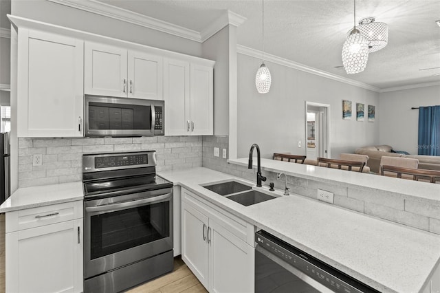 3611 19th St N, Saint Petersburg, FL 33713 - kitchen with stainless steel appliances, a sink, open floor plan, light wood finished floors, and decorative backsplash