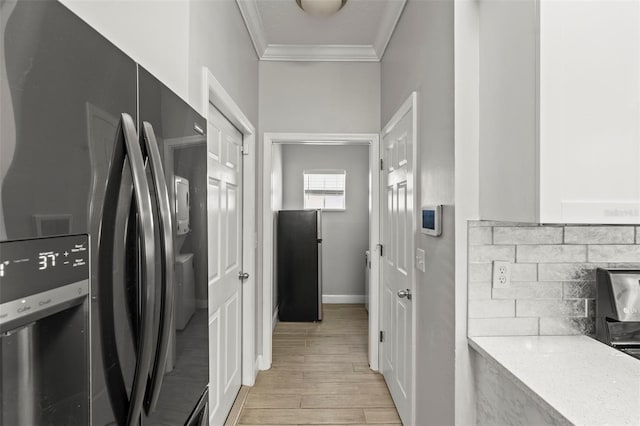 3611 19th St N, Saint Petersburg, FL 33713 - kitchen with black fridge, ornamental molding, light wood-type flooring, decorative backsplash, and baseboards