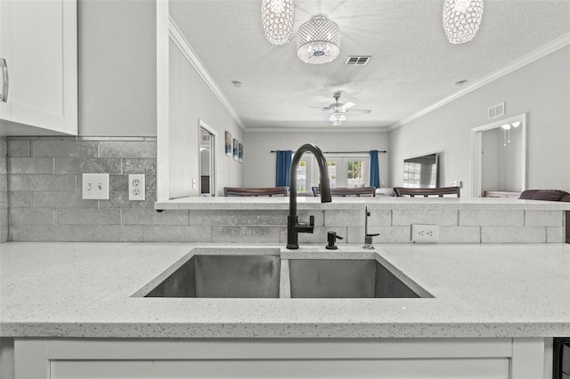 3611 19th St N, Saint Petersburg, FL 33713 - kitchen with a sink, ornamental molding, a textured ceiling, open floor plan, and light stone countertops
