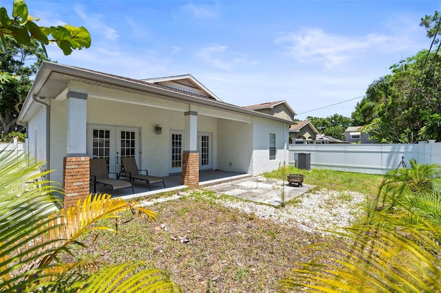 3611 19th St N, Saint Petersburg, FL 33713 - back of property with stucco siding, french doors, a patio area, an outdoor fire pit, and central AC unit