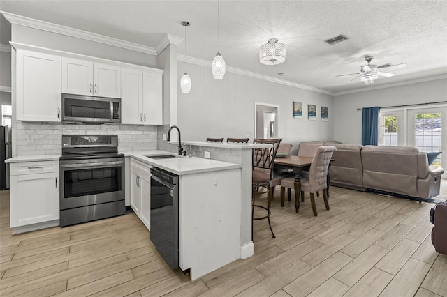3611 19th St N, Saint Petersburg, FL 33713 - kitchen with appliances with stainless steel finishes, a sink, open floor plan, a peninsula, and a kitchen bar