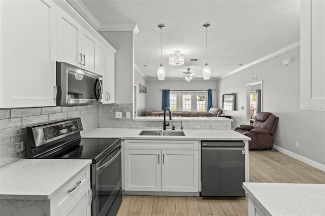 3611 19th St N, Saint Petersburg, FL 33713 - kitchen with stainless steel appliances, a sink, crown molding, open floor plan, and a peninsula