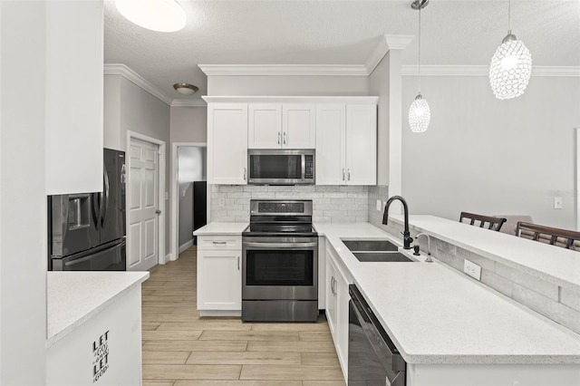 3611 19th St N, Saint Petersburg, FL 33713 - kitchen featuring appliances with stainless steel finishes, a sink, a peninsula, a textured ceiling, and tasteful backsplash