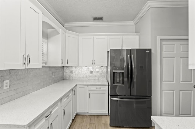 3611 19th St N, Saint Petersburg, FL 33713 - kitchen featuring refrigerator with ice dispenser, white cabinetry, crown molding, backsplash, and a textured ceiling