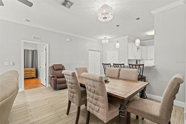 3611 19th St N, Saint Petersburg, FL 33713 - dining area featuring light wood-style floors, ornamental molding, a ceiling fan, a textured ceiling, and baseboards