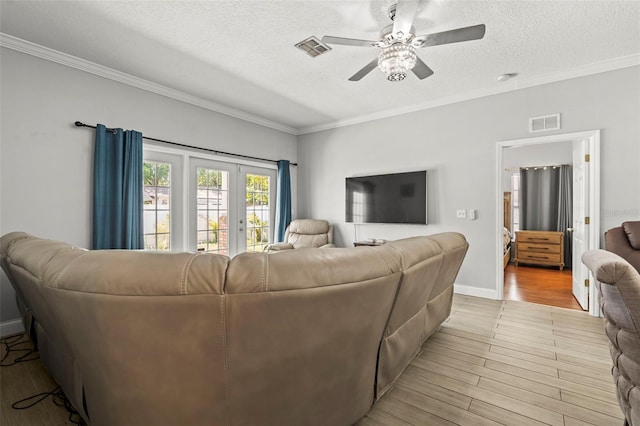 3611 19th St N, Saint Petersburg, FL 33713 - living room featuring light wood-style floors, a ceiling fan, crown molding, a textured ceiling, and baseboards