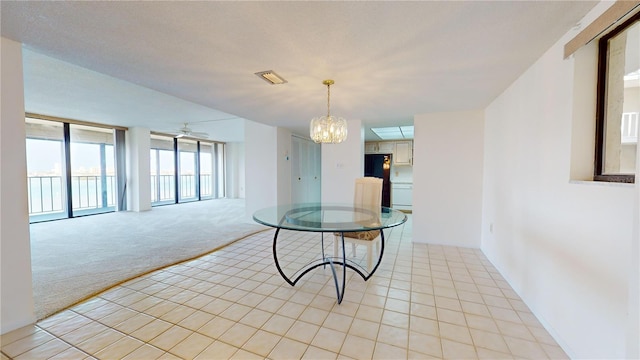 carpeted dining area with ceiling fan with notable chandelier