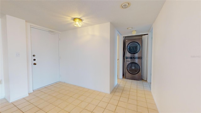 interior space featuring a textured ceiling and stacked washer and clothes dryer