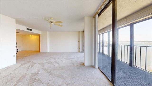 carpeted spare room featuring ceiling fan