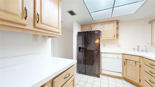 kitchen with light brown cabinetry, black fridge with ice dispenser, sink, light tile patterned floors, and dishwasher