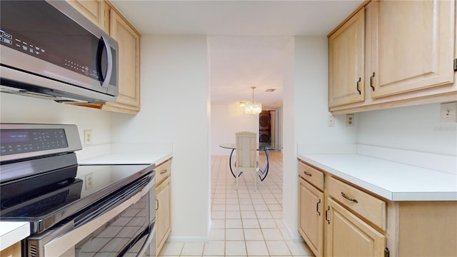 kitchen with light brown cabinets, hanging light fixtures, light tile patterned floors, appliances with stainless steel finishes, and a chandelier