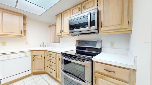 kitchen featuring light tile patterned flooring, light brown cabinetry, stainless steel appliances, and sink