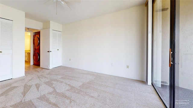 unfurnished bedroom featuring light carpet, ceiling fan, and multiple closets