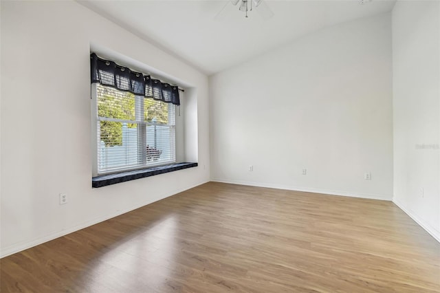 empty room featuring ceiling fan, light hardwood / wood-style floors, and vaulted ceiling