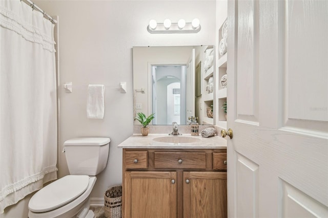 bathroom featuring walk in shower, vanity, and toilet