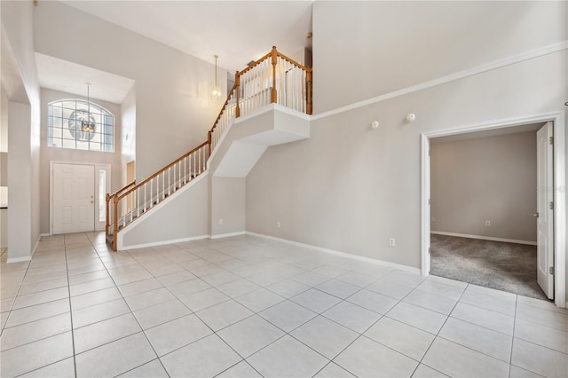 entrance foyer with light tile patterned floors, a towering ceiling, and an inviting chandelier