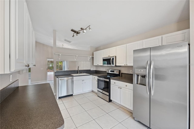 kitchen featuring white cabinetry, sink, light tile patterned floors, and stainless steel appliances