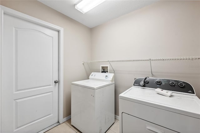 clothes washing area featuring light tile patterned flooring and independent washer and dryer