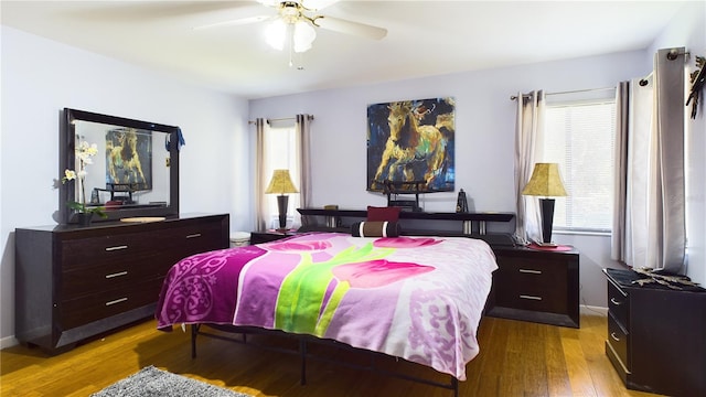 bedroom featuring multiple windows, ceiling fan, and light wood-type flooring