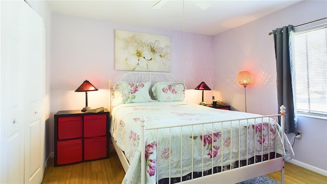 bedroom with hardwood / wood-style flooring, ceiling fan, and a closet