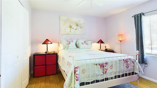 bedroom with hardwood / wood-style floors, ceiling fan, and a closet