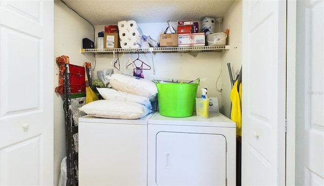 clothes washing area with separate washer and dryer and a textured ceiling