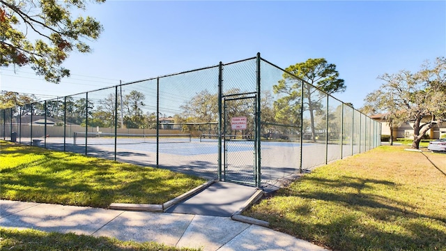 view of tennis court with a lawn