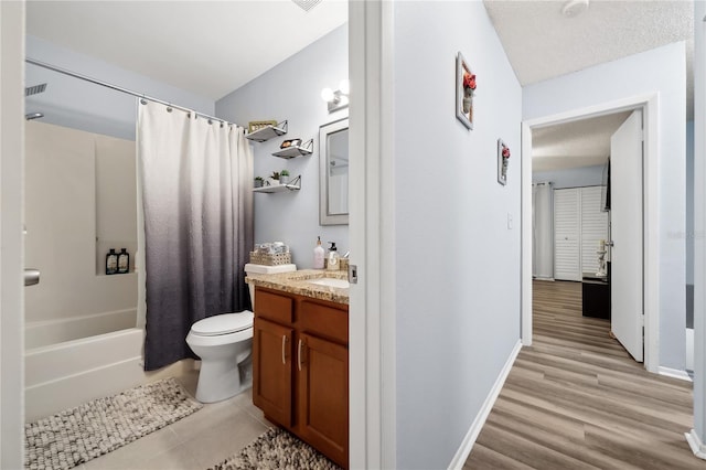 full bathroom featuring shower / bath combo with shower curtain, a textured ceiling, toilet, and vanity