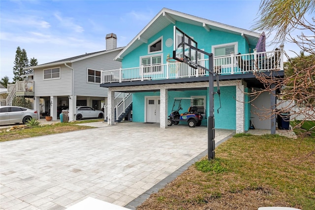 coastal home featuring a carport, a front yard, and a wooden deck