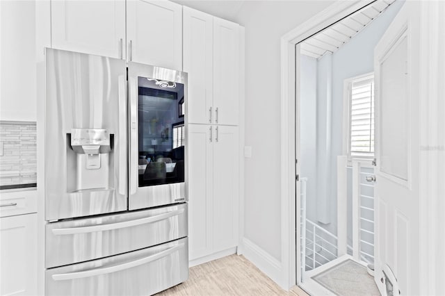 kitchen with white cabinets, stainless steel fridge with ice dispenser, and tasteful backsplash