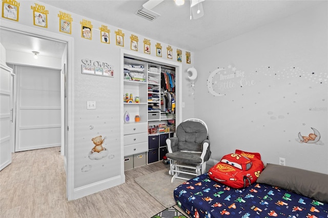 bedroom with ceiling fan, light wood-type flooring, and a closet