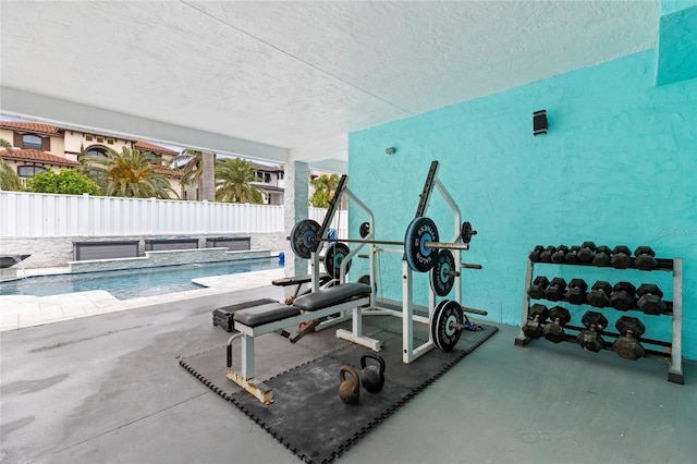 workout area with a textured ceiling and a swimming pool