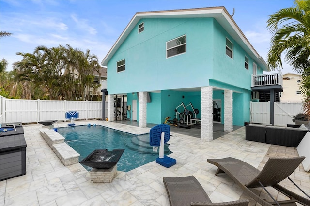 view of swimming pool featuring a patio area and an outdoor living space with a fire pit