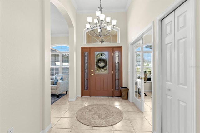 entryway with light tile patterned flooring, a chandelier, and ornamental molding