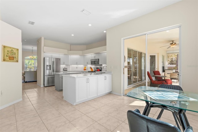 kitchen featuring ceiling fan, white cabinets, light tile patterned floors, and appliances with stainless steel finishes