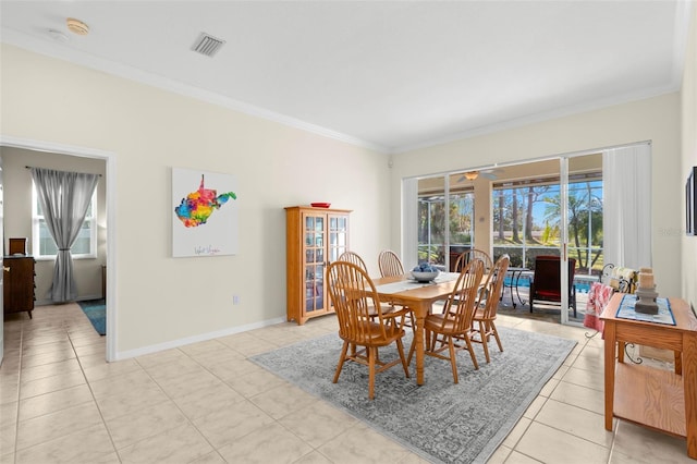 dining room featuring light tile patterned floors and crown molding