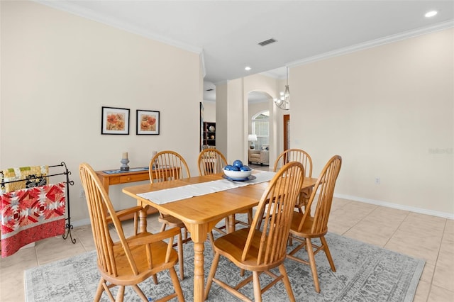 dining room with a chandelier, ornamental molding, and light tile patterned flooring