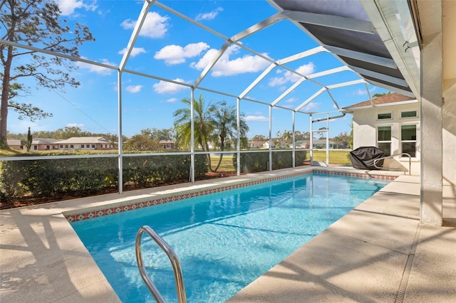 view of swimming pool with glass enclosure and a patio area