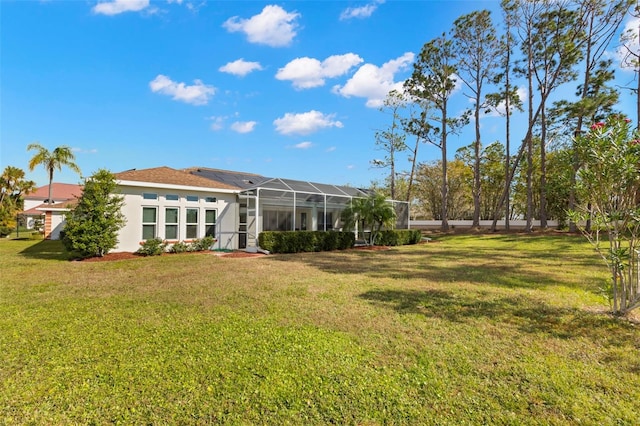 back of property with a lanai and a yard