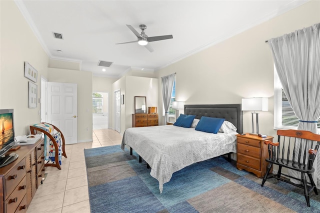 bedroom with ceiling fan, light tile patterned floors, ornamental molding, and ensuite bath