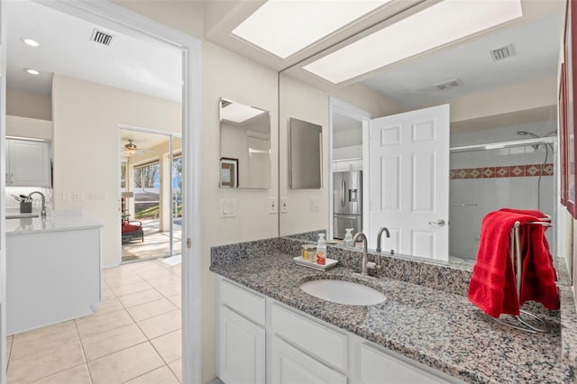 bathroom featuring tile patterned flooring, ceiling fan, an enclosed shower, and vanity