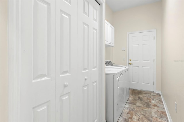 laundry room featuring separate washer and dryer and cabinets