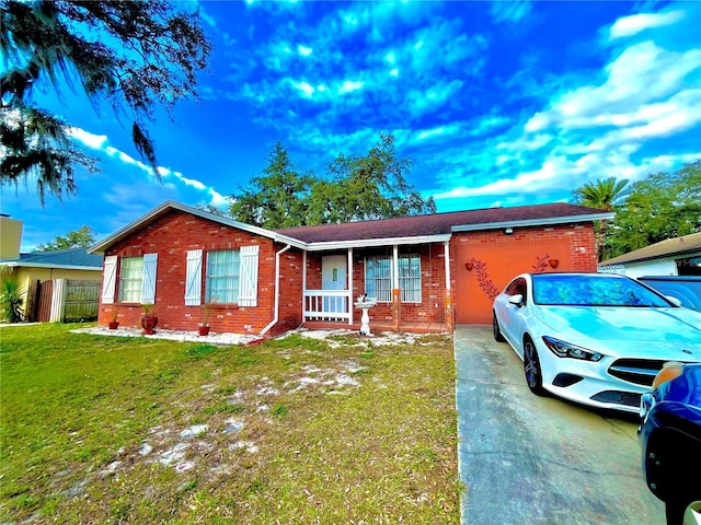 ranch-style house featuring a front lawn, covered porch, and a garage