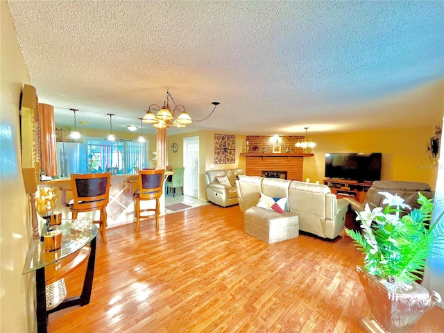 living room with a textured ceiling, light hardwood / wood-style floors, and a notable chandelier