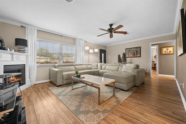 living room featuring hardwood / wood-style flooring, crown molding, and ceiling fan