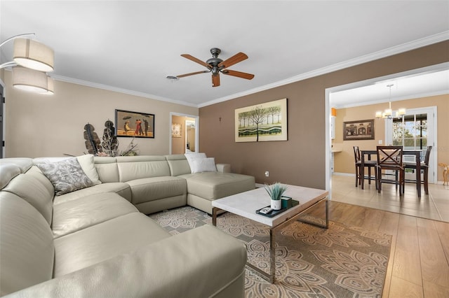 living room featuring light wood-type flooring, crown molding, and ceiling fan with notable chandelier