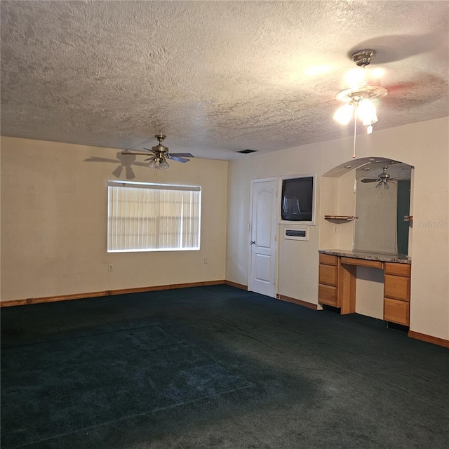 unfurnished living room featuring dark carpet and a textured ceiling