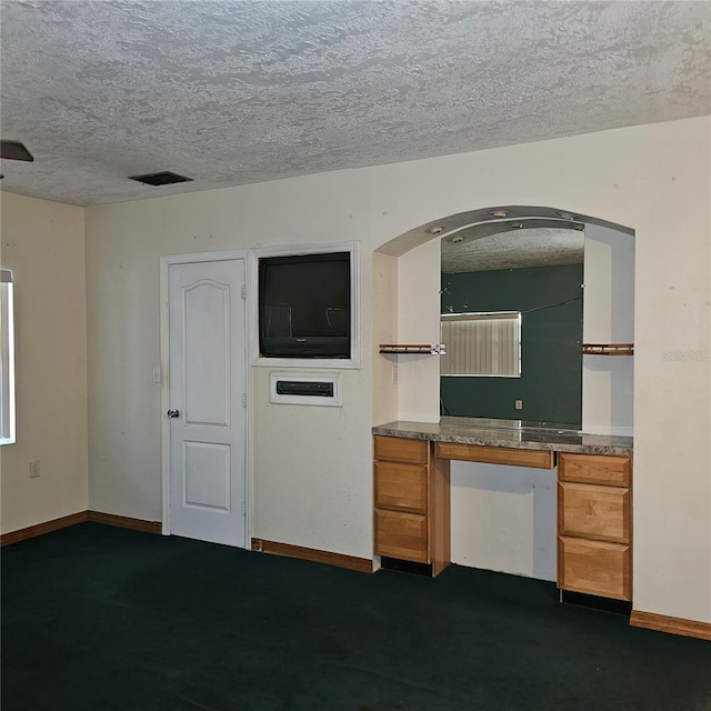 kitchen featuring a textured ceiling and built in desk