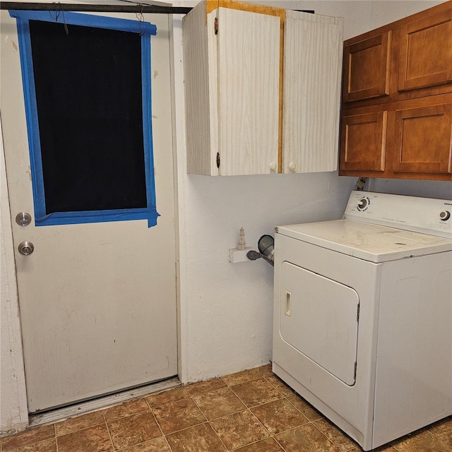 clothes washing area featuring cabinets and washer / clothes dryer