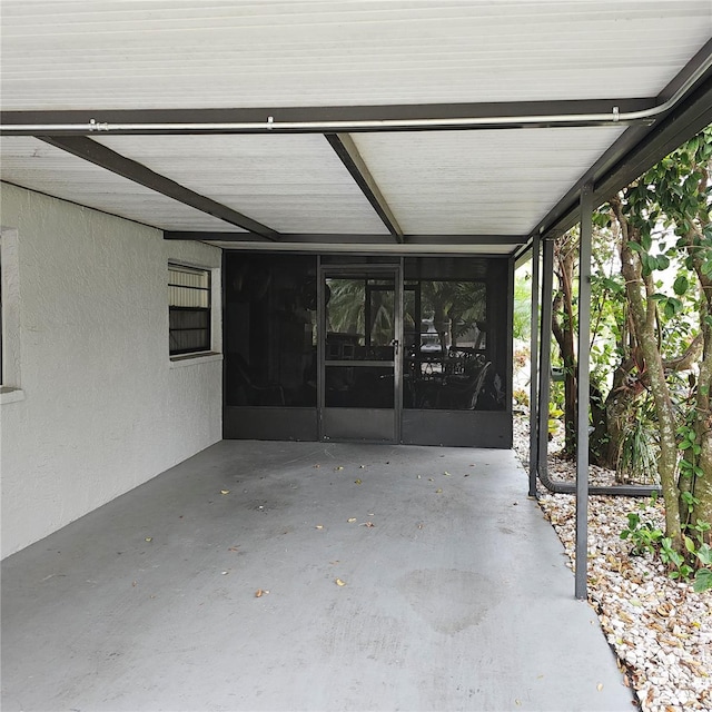 view of patio featuring a carport and a sunroom